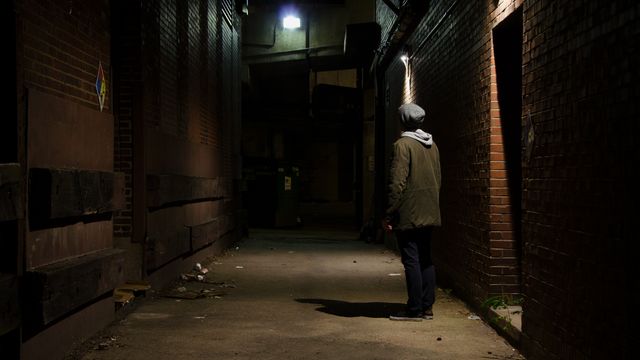 Person Standing in Dark Alley at Night Near Dim Light - Download Free Stock Photos Pikwizard.com