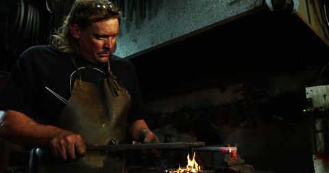 Experienced Blacksmith Skillfully Crafting in Workshop