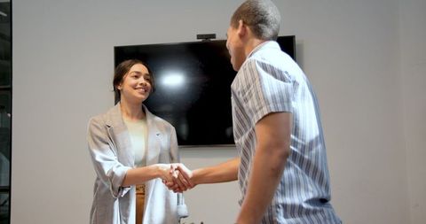 Multiracial colleagues shaking hands in modern office