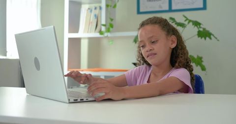 African American Girl Typing on Laptop at Bright Desk Studying Online Learning Remotely