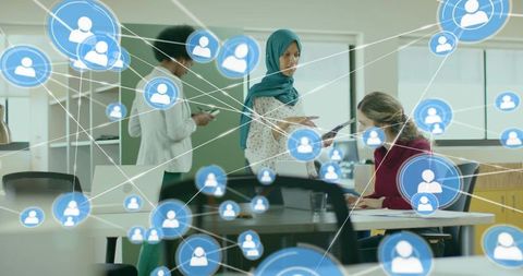 Consultant in teal hijab presenting tablet to colleague in collaborative office network