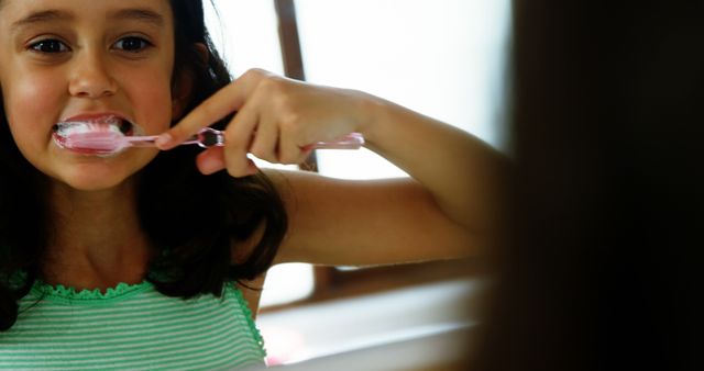 Young Girl Brushing Teeth with Pink Toothbrush in Bathroom - Download Free Stock Images Pikwizard.com