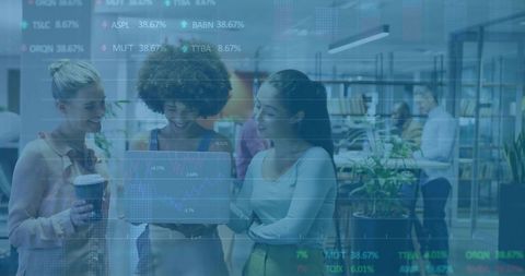 Collaborating over laptop displaying stock charts overlay in modern coworking office