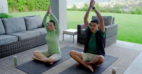 Couple Practicing Yoga Outdoors for Wellness and Relaxation