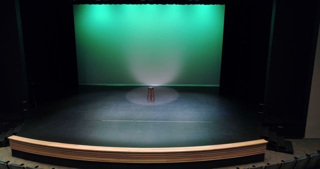 Minimalistic theatrical stage with single spotlight illuminating a stool. Perfect visual for performance advertisements, theater promotions, motivational quotes, or dramatic storytelling backdrops.