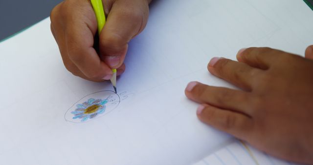 Close-up of schoolboy drawing pictures in classroom at school