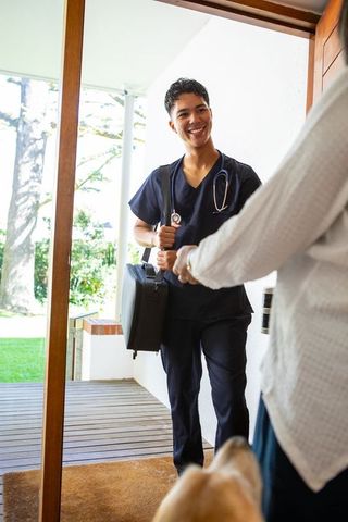 Healthcare professional visiting senior at home on outdoor porch