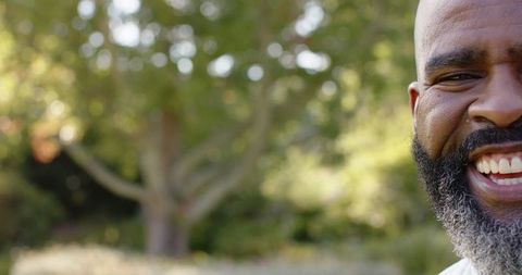 Smiling Bearded Man Enjoying Nature in Sunny Park