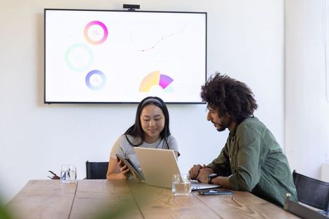 Diverse team collaborating in meeting room with digital technology