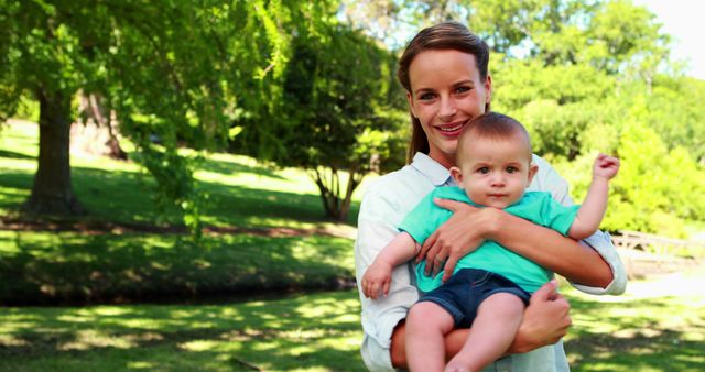 Happy Mother Holding Baby in Park on Sunny Day - Download Free Stock Images Pikwizard.com