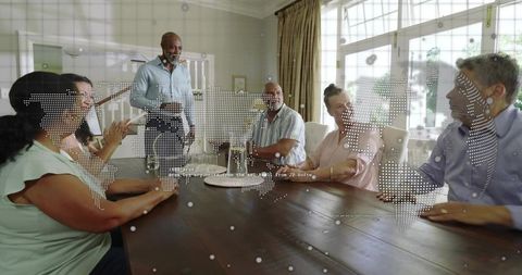 Adults gathering around wooden table with world map overlay for global teamwork