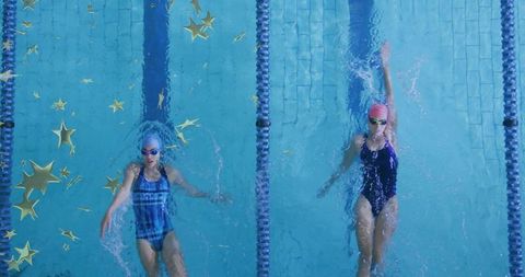 Overhead view two swimmers racing backstroke with gold star confetti in blue lap pool