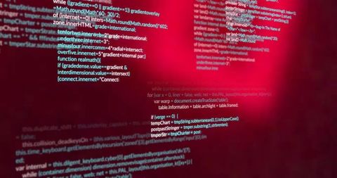 Colorful source code on multiple screens at workstation