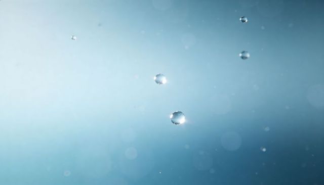 Floating water droplets with soft blue bokeh, macro spheres and sparkling highlights