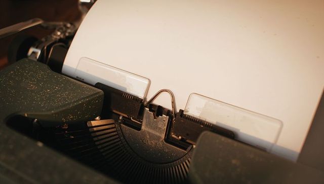Vintage typewriter with blank paper in warm lighting