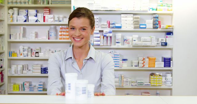 Portrait of pharmacist holding medicine container in pharmacy