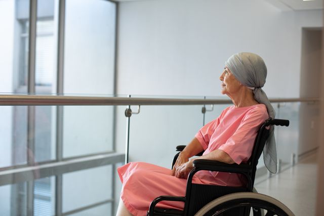 Happy senior caucasian female patient in wheelchair, smiling in hospital corridor, with copy space. Medical services, hospital and healthcare concept.