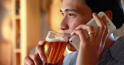 Man Multitasking with Phone Call and Beer Cheers in Relaxed Atmosphere - Download Free Stock Images Pikwizard.com