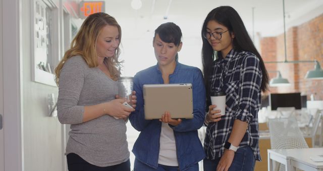 Young Women Discussing Project on Digital Tablet in Modern Office - Download Free Stock Images Pikwizard.com