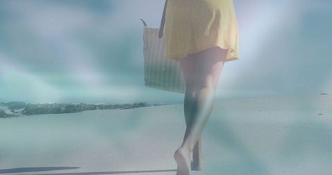 Woman in Yellow Dress Walking by Seaside Carrying Tote