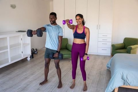 Diverse Couple Lifting Dumbbells for Home Fitness