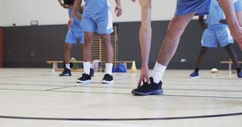 Diverse Basketball Team Stretching on Indoor Court
