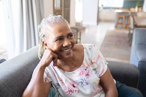 Senior Woman Relaxing on Sofa in Bright Living Room