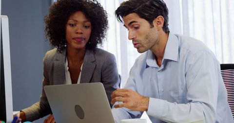 Professionals Collaborating at Laptop in Modern Office