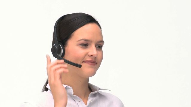 Woman is talking on a headset, suggesting customer support or call center environment. Useful for depicting remote work, professional communication, or business interaction concepts.