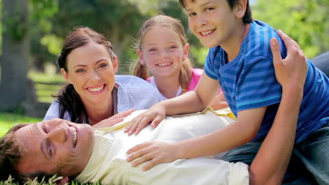 Happy Family Relaxing Together on Green Meadow