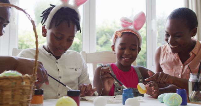 African american family painting easter eggs together at home. easter holiday spirit and joy concept