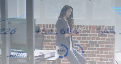 Woman Analyzing Data on Digital Tablet in Office Environment