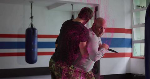 Knife-defense training drill: close-quarter grappling and disarm practice in martial arts gym