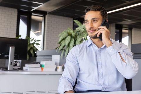 Confident Professional Multitasking with Smartphone in Modern Office