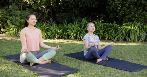 Mother and Daughter Meditating in Home Garden Enhancing Wellness