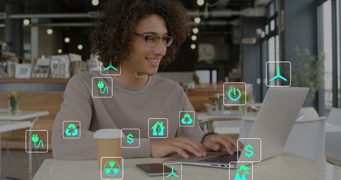 Freelancer typing on laptop in cafe with green sustainability and renewable energy icons overlay