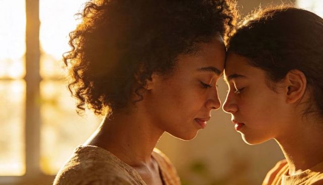 Mother daughter forehead touching tender connection in golden hour backlit portrait