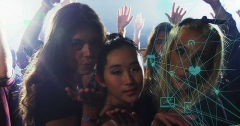 Young women sending kisses at concert with overlay of social media connections
