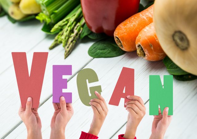 Digital composite image of world vegan day text held by hands against vegetables on table. healthy lifestyle and vegetarianism.