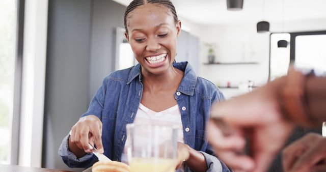 Smiling Woman Enjoying Breakfast at Home Spreading Butter on Toast - Download Free Stock Images Pikwizard.com