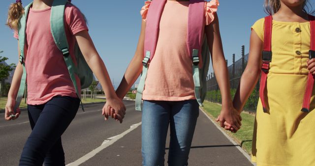 Young girls holding hands while walking on sunny day - Download Free Stock Images Pikwizard.com