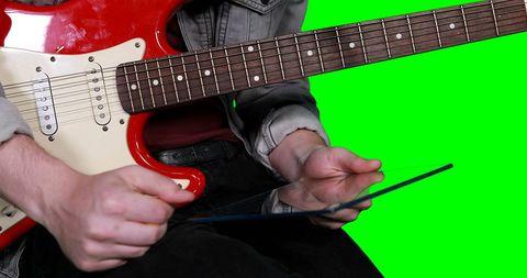 Musician blending technology and tradition with guitar and tablet