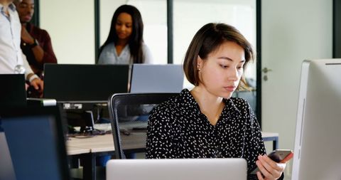 Businesswoman Using Mobile Phone at Modern Office Desk