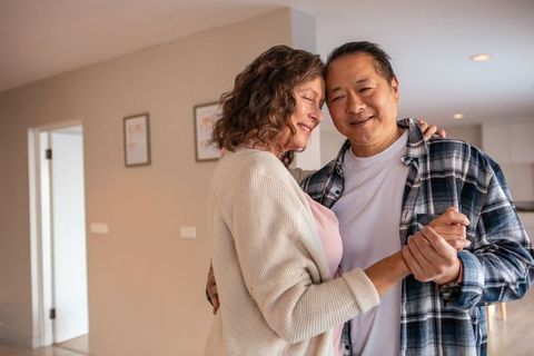 Diverse Senior Couple Embracing and Dancing in Contemplative Space