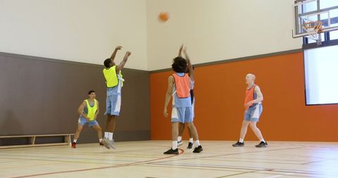 Energetic Male Athletes Playing Basketball in Indoor Gym