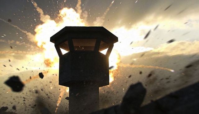 Concrete watchtower silhouetting against exploding fireball with flying debris and smoke