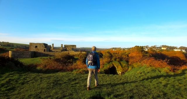 Male Hiker Exploring Serene Landscape with Historic Ruins - Download Free Stock Images Pikwizard.com