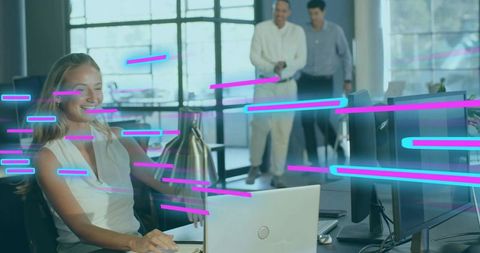 Smiling professional woman typing at laptop in modern office with neon data streaks