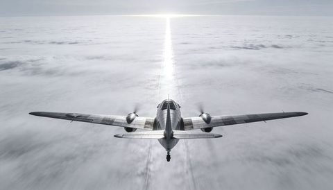 Twin-engine vintage aircraft flying over cloud deck with sun glint and spinning propellers
