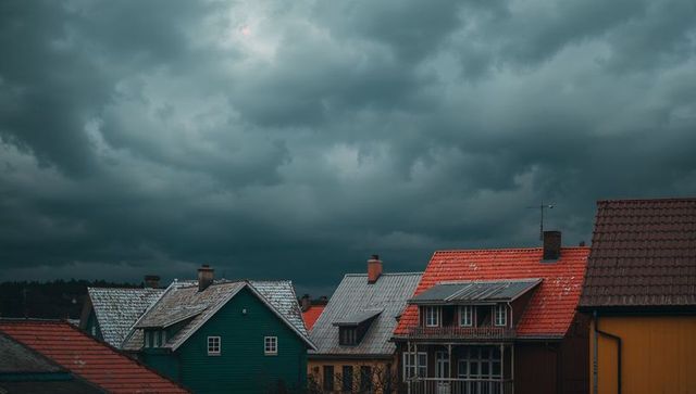 Storm clouds gathering over colorful pitched rooftops and chimneys in small town